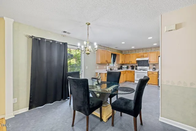 a dining room with furniture a chandelier and wooden floor