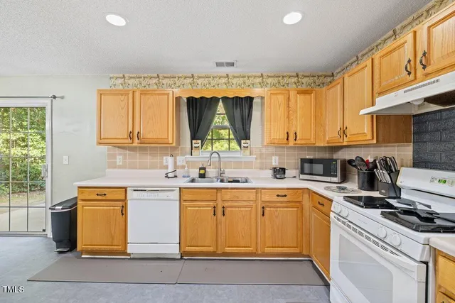 a kitchen with a sink window and cabinets