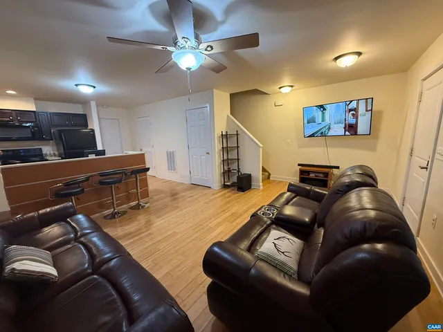 a living room with furniture and a ceiling fan
