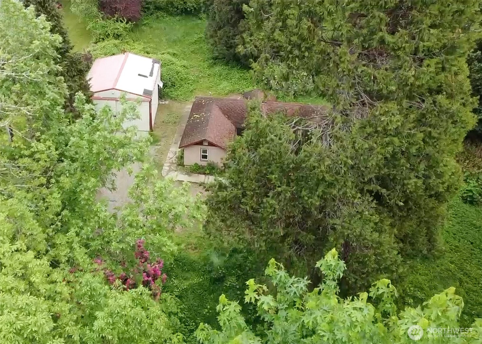an aerial view of a house with a yard and trees