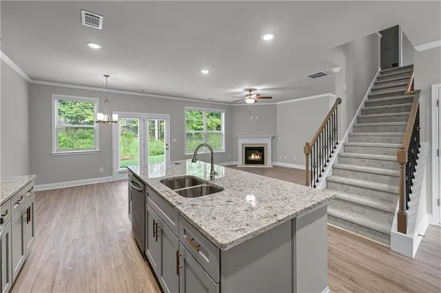 a kitchen with granite countertop a sink a counter top space and stainless steel appliances