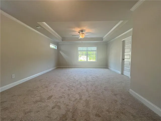 an empty room with windows and ceiling fan