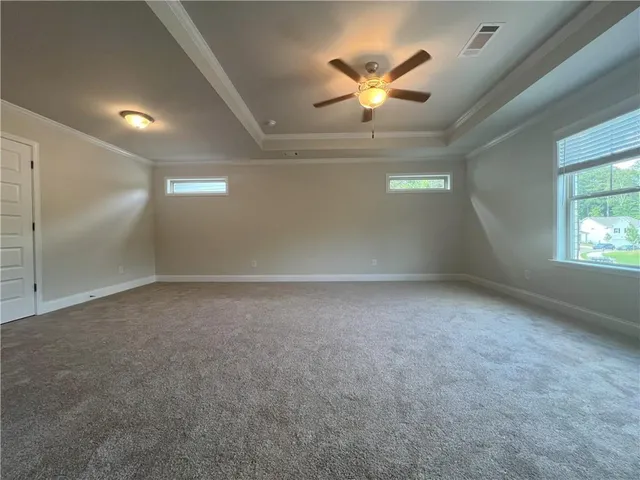en empty room with windows and ceiling fan