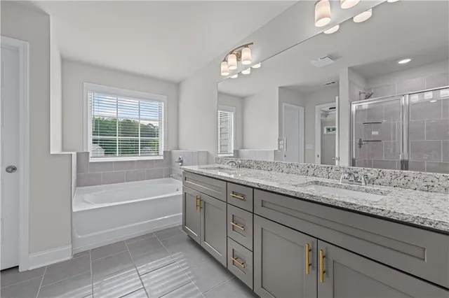 a bathroom with a granite countertop sink a large mirror and a bathtub with shower