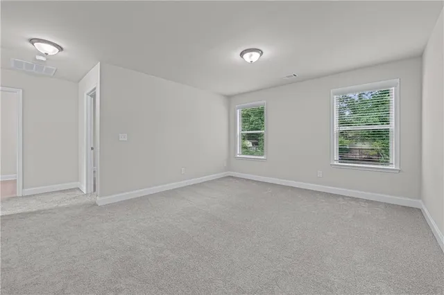 an empty room with windows and closet