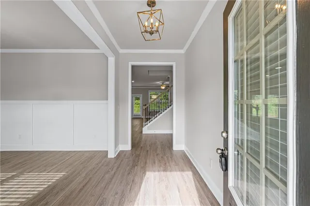 a view of a hallway with wooden floor and a bathroom