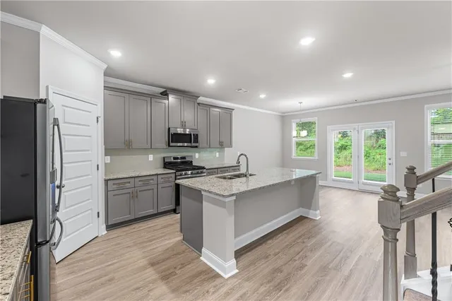 a kitchen with stainless steel appliances granite countertop a stove refrigerator and a large window