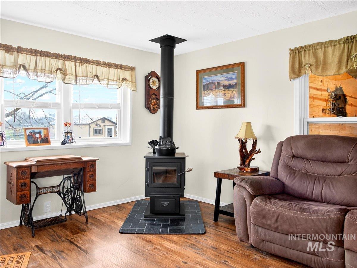 9228 Washoe Road Payette, ID 83661 - Photo 15 of 49 Living area featuring wood finished floors and a wood stove