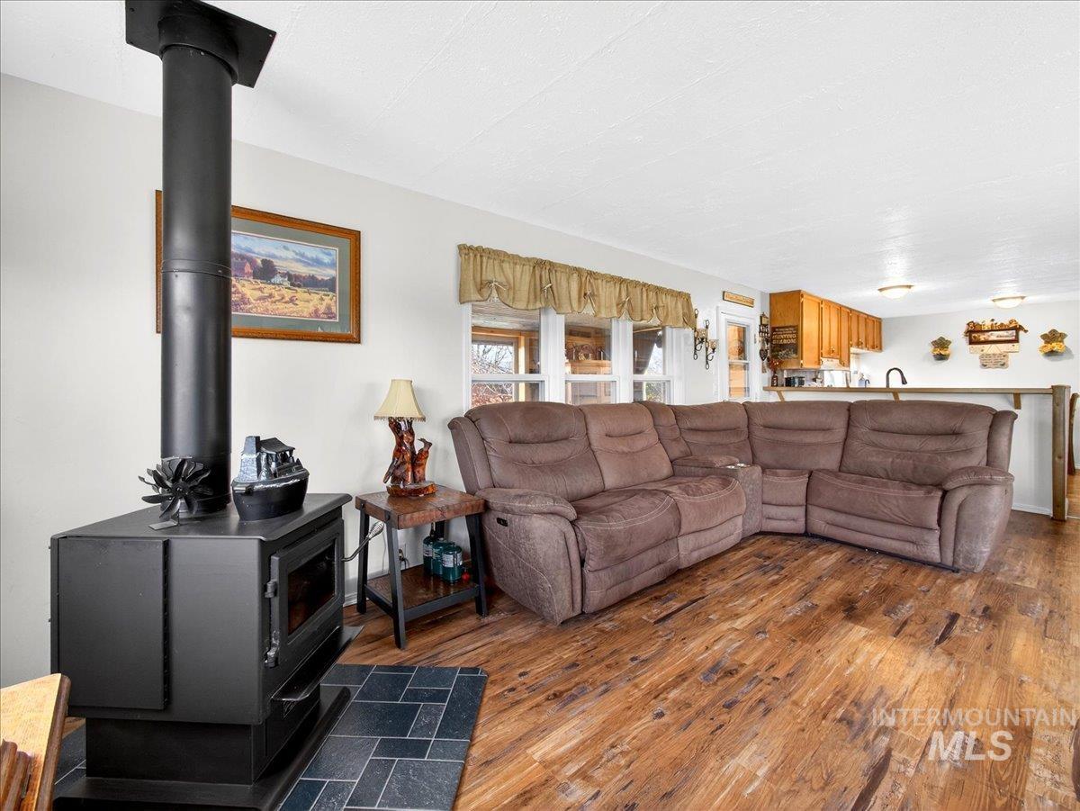 9228 Washoe Road Payette, ID 83661 - Photo 17 of 49 Living area with dark wood-style flooring and a wood stove