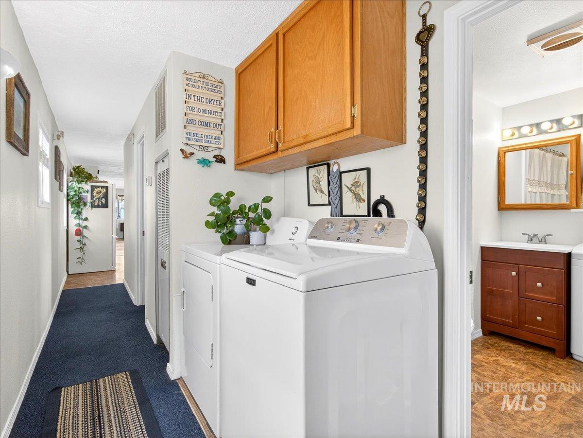 9228 Washoe Road Payette, ID 83661 - Photo 29 of 49 Laundry room featuring dark carpet, cabinet space, a textured ceiling, independent washer and dryer, and a heating unit