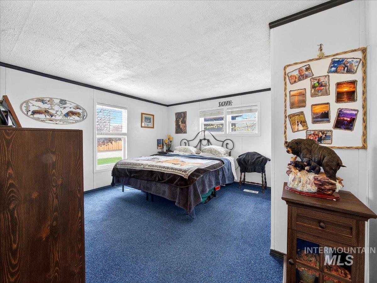 9228 Washoe Road Payette, ID 83661 - Photo 32 of 49 Carpeted bedroom featuring a textured ceiling and crown molding