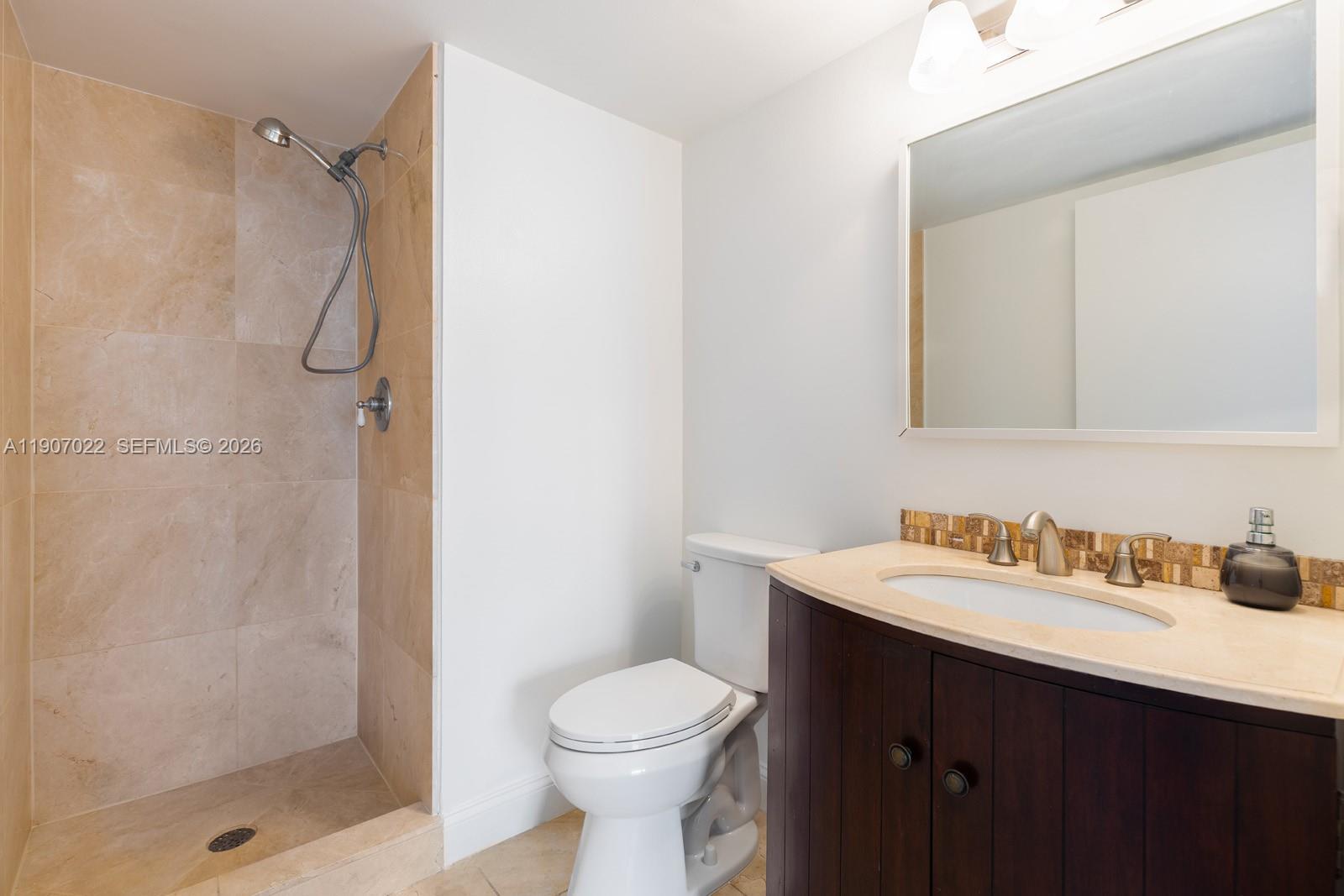 1621 Bay Road, Unit 604 Miami Beach, FL 33139 - Photo 9 of 30 a bathroom with a sink toilet and shower