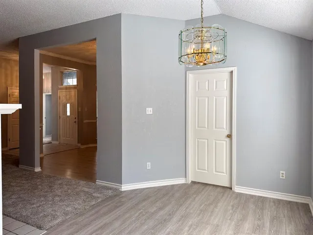 an empty room that has a window and wooden floor