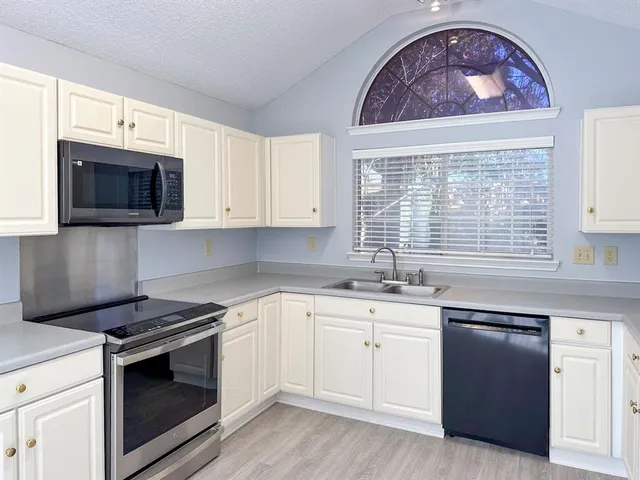 a kitchen with stainless steel appliances a stove a sink and a microwave