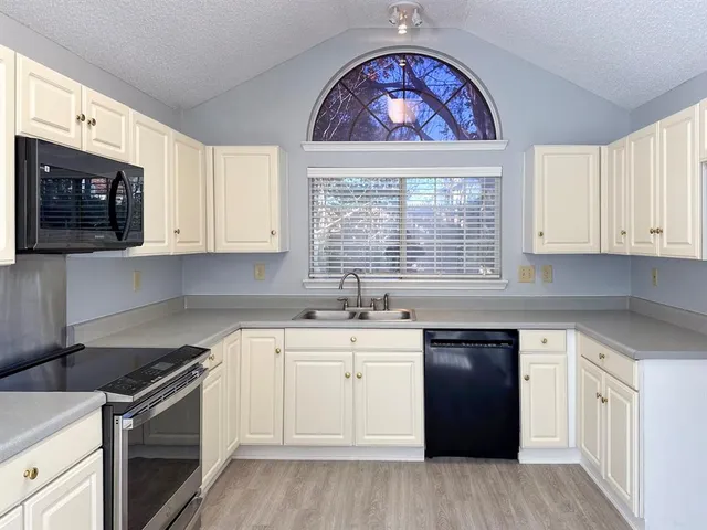 a kitchen with stainless steel appliances a stove a sink and a microwave