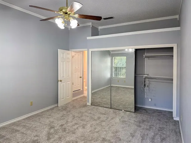 a view of an empty room with a ceiling fan