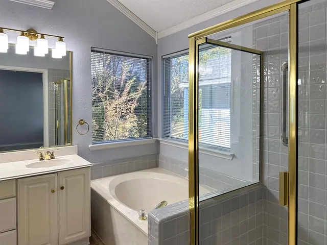 a bathroom with a tub sink and mirror