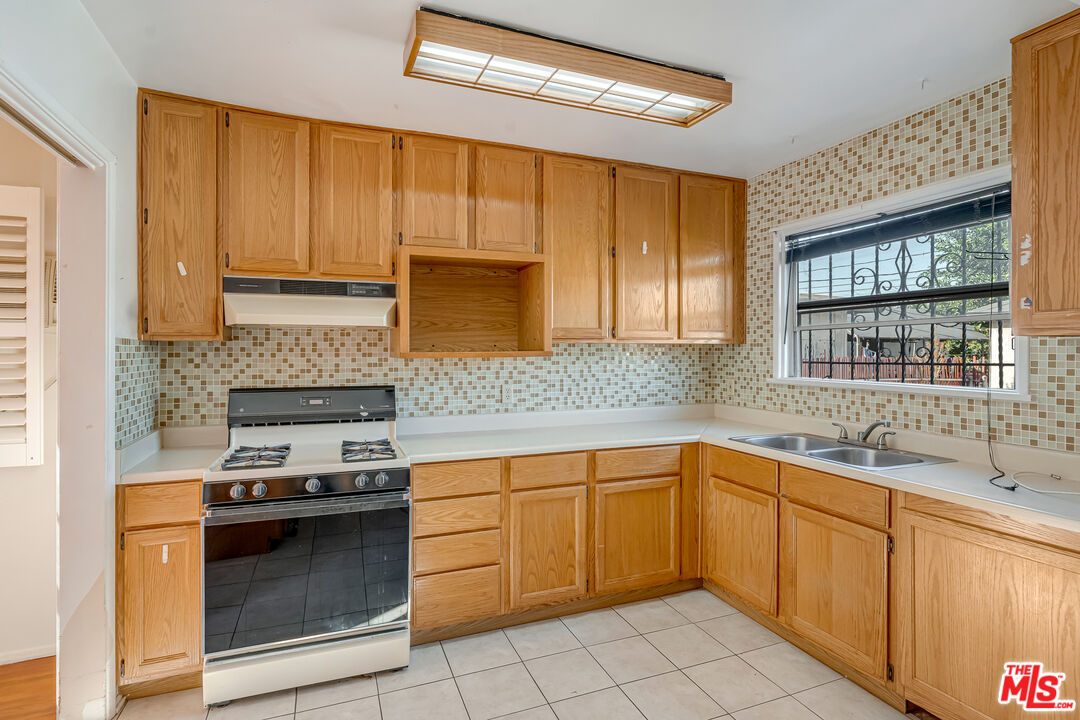 331 East 119th Street Los Angeles, CA 90061 - Photo 11 of 40 a kitchen with a sink stove and cabinets