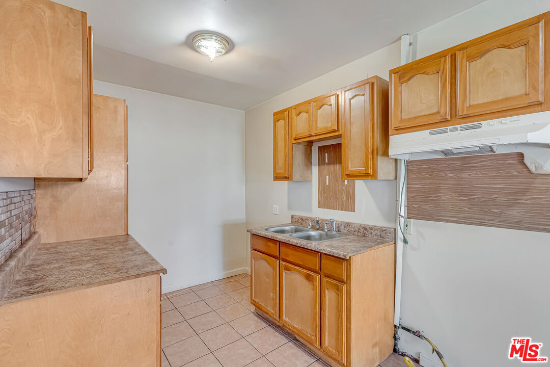 331 East 119th Street Los Angeles, CA 90061 - Photo 26 of 40 a kitchen with stainless steel appliances granite countertop a sink stove and cabinets