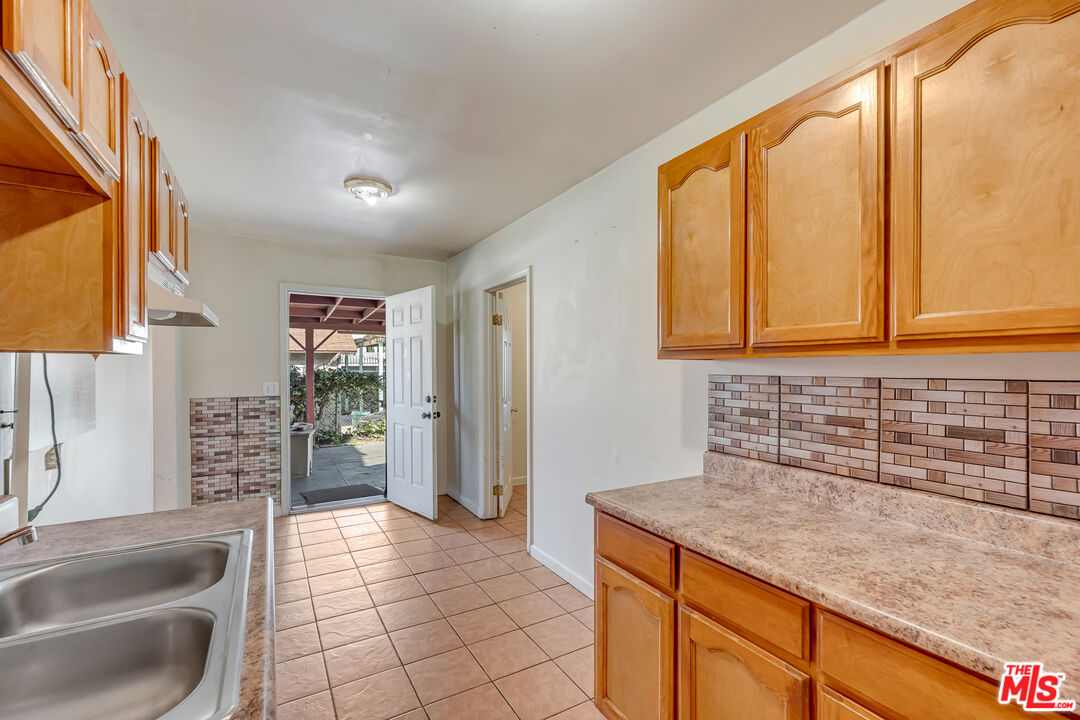 331 East 119th Street Los Angeles, CA 90061 - Photo 27 of 40 a kitchen with granite countertop a sink and a refrigerator