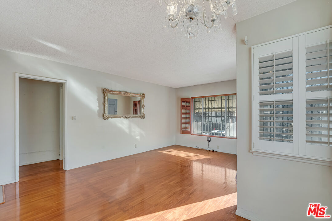 331 East 119th Street Los Angeles, CA 90061 - Photo 4 of 40 a view of an empty room with wooden floor and a window