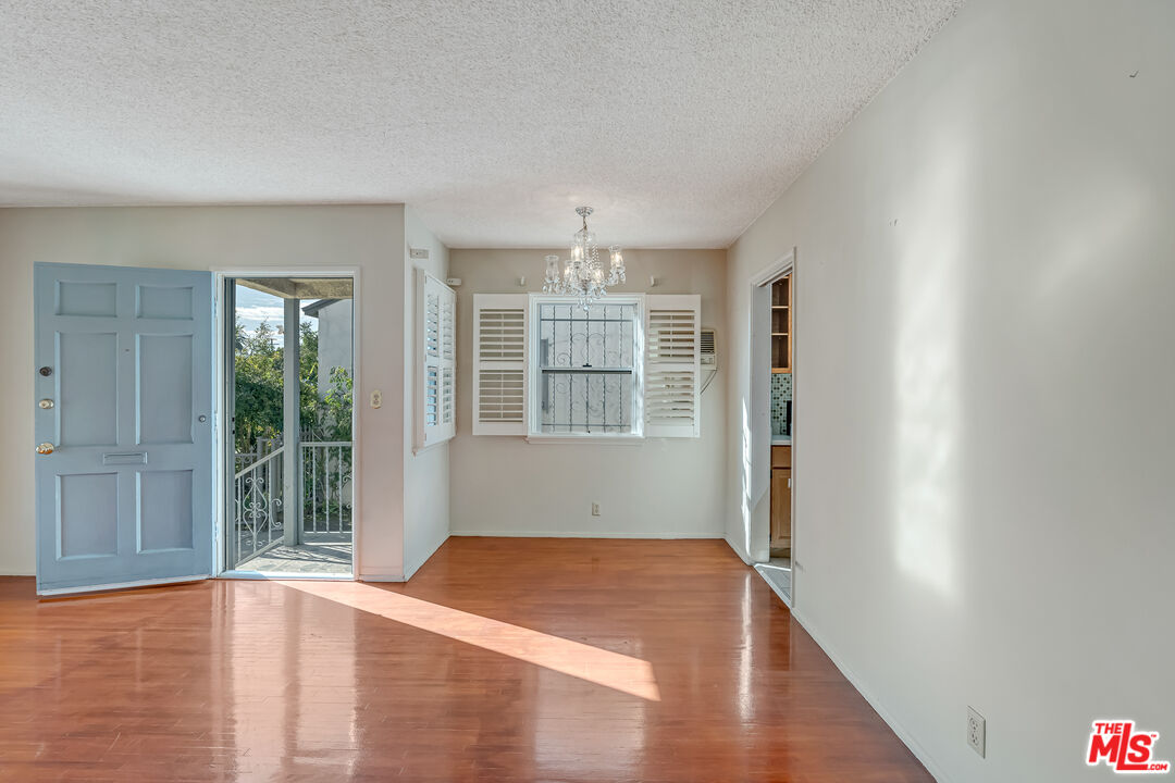 331 East 119th Street Los Angeles, CA 90061 - Photo 6 of 40 a view of an empty room with wooden floor and a window