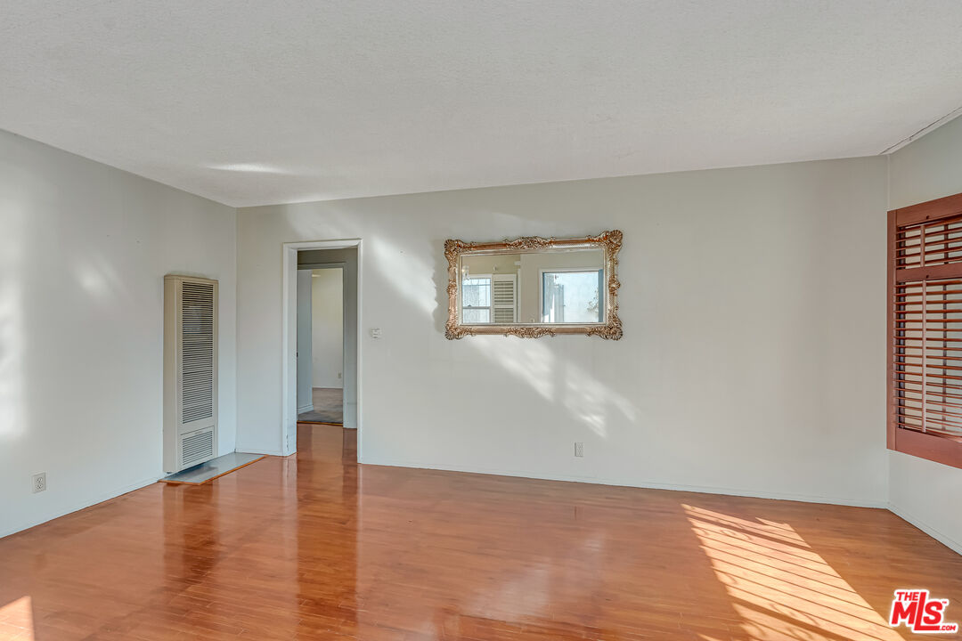 331 East 119th Street Los Angeles, CA 90061 - Photo 7 of 40 a view of an empty room with wooden floor and a window