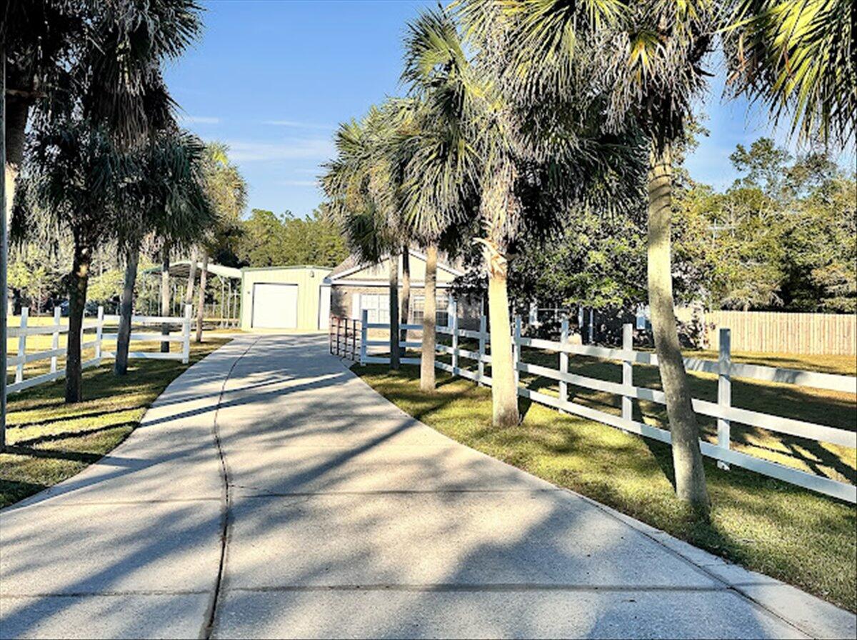 208 Hinote Road DeFuniak Springs, FL 32433 - Photo 11 of 49 a view of a swimming pool with a lounge chair and palm trees
