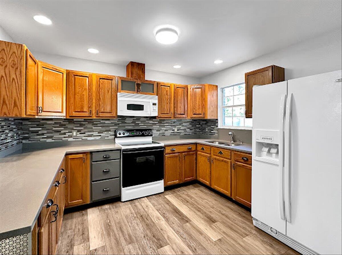 208 Hinote Road DeFuniak Springs, FL 32433 - Photo 21 of 49 a kitchen with stainless steel appliances granite countertop a refrigerator a sink dishwasher a stove and white countertops with wooden floor