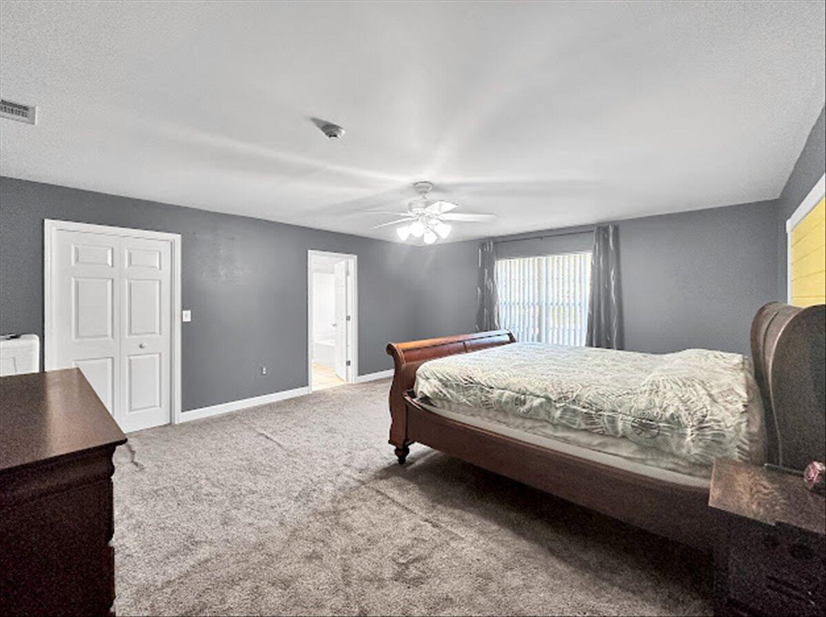 208 Hinote Road DeFuniak Springs, FL 32433 - Photo 23 of 49 a spacious bedroom with a bed and a chandelier