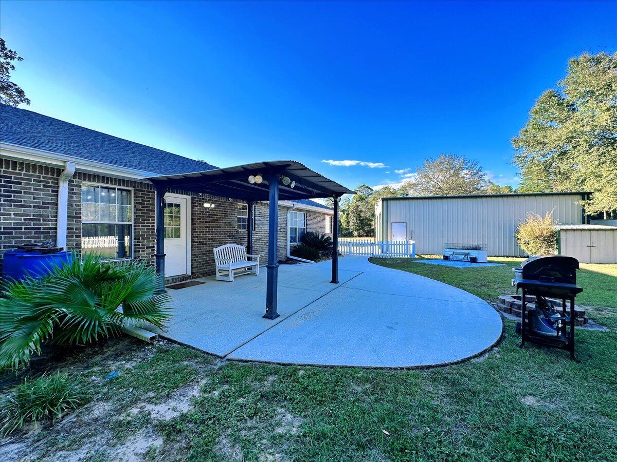 208 Hinote Road DeFuniak Springs, FL 32433 - Photo 38 of 49 a view of a house with backyard sitting area and garden