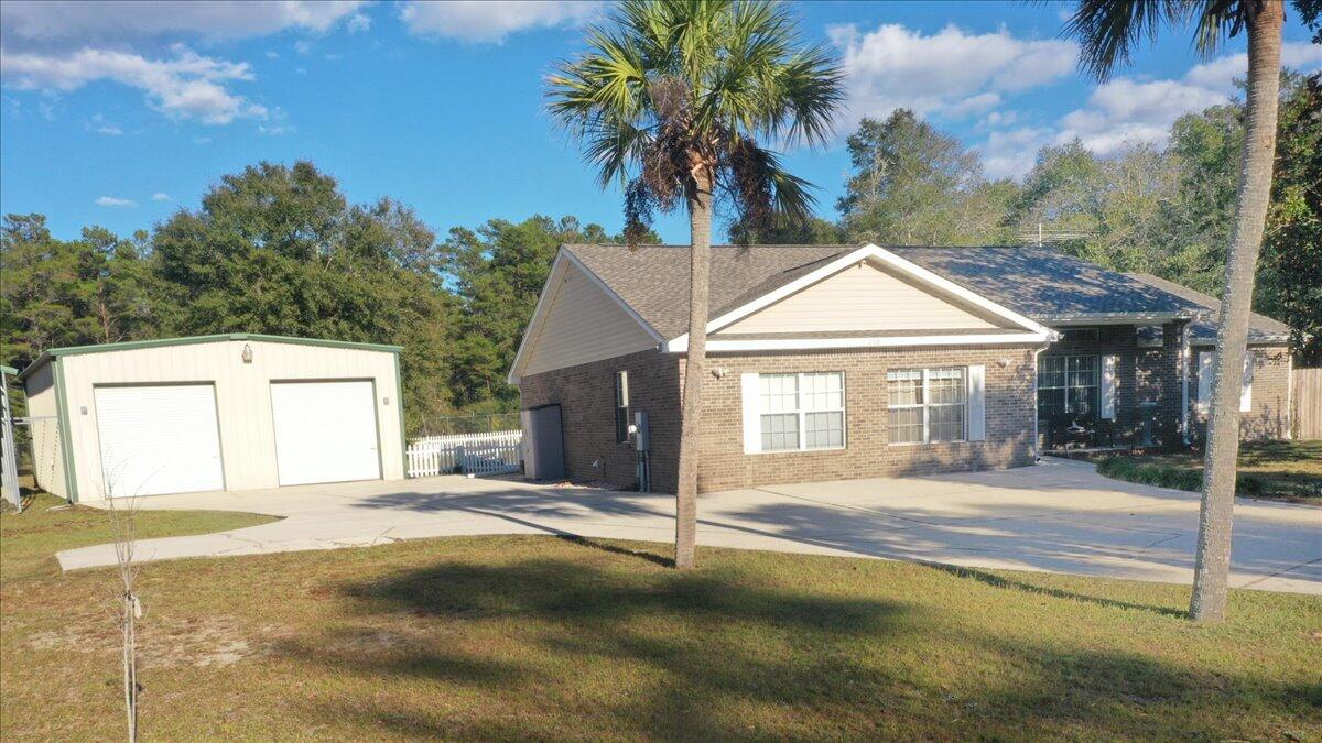 208 Hinote Road DeFuniak Springs, FL 32433 - Photo 6 of 49 a front view of a house with a yard and garage