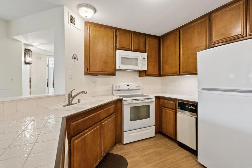 17607 Pomerado Road, Unit 101 San Diego, CA 92128 - Photo 11 of 39 a kitchen with stainless steel appliances granite countertop a sink stove and refrigerator