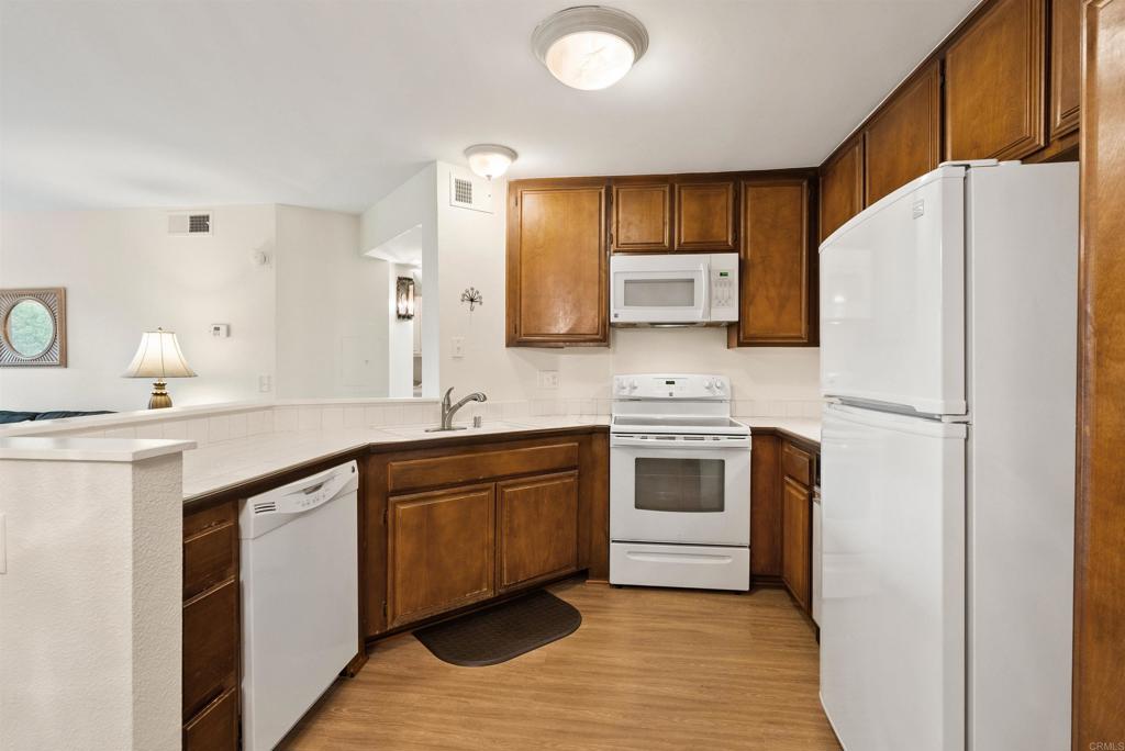 17607 Pomerado Road, Unit 101 San Diego, CA 92128 - Photo 12 of 39 a kitchen with stainless steel appliances a refrigerator sink and microwave