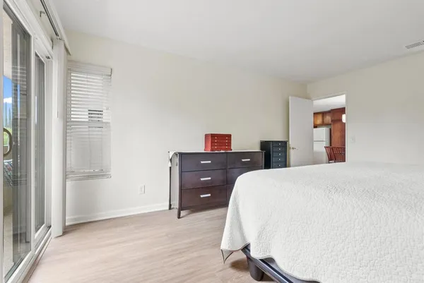 a bedroom with a bed and wooden floor