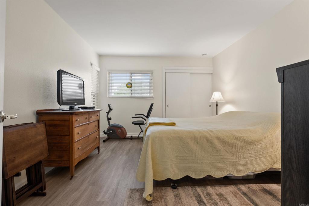 17607 Pomerado Road, Unit 101 San Diego, CA 92128 - Photo 28 of 39 a bedroom with a bed and wooden floor