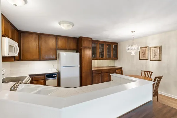 a kitchen with stainless steel appliances kitchen island granite countertop a refrigerator a stove a sink dishwasher with a dining table and chairs