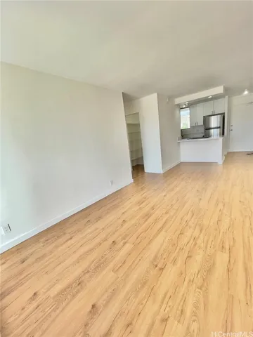 a view of empty room with wooden floor
