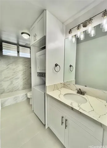 a bathroom with a granite countertop sink mirror and a toilet