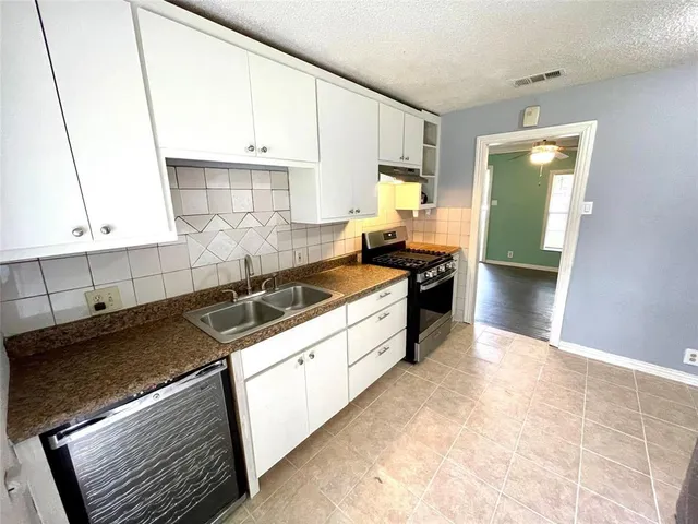 a kitchen with a sink stove and cabinets