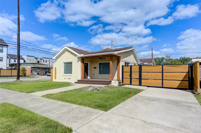 a view of a house with a yard and large tree