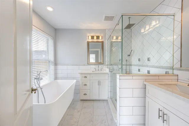 a bathroom with a tub sink and mirror