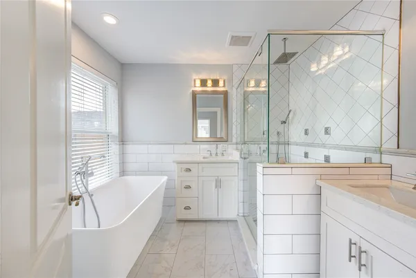 a bathroom with a tub sink and mirror