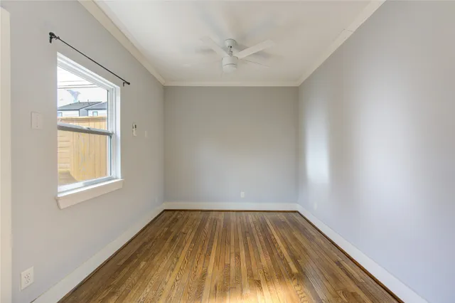 an empty room with a window and wooden floor