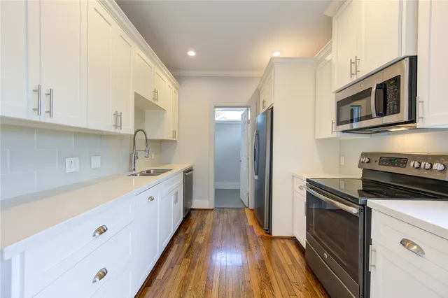 a kitchen with stainless steel appliances a sink dishwasher a refrigerator and a stove top oven