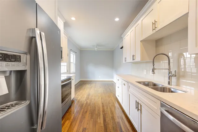 a kitchen with a sink a refrigerator and cabinets