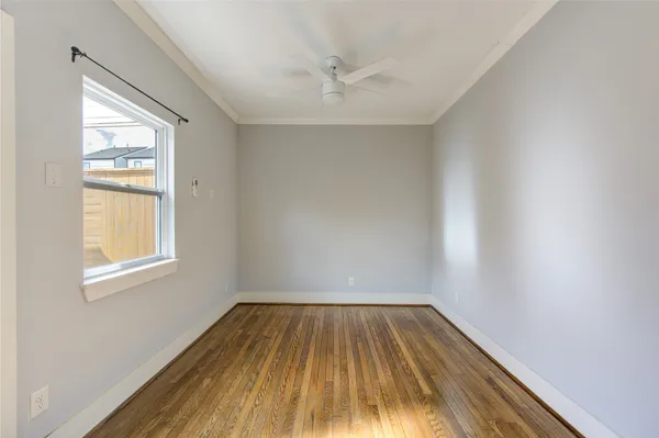 an empty room with a window and wooden floor