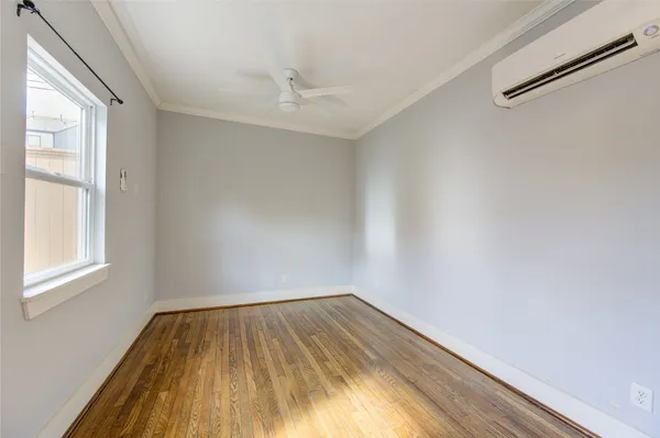 a view of empty room with wooden floor and fan