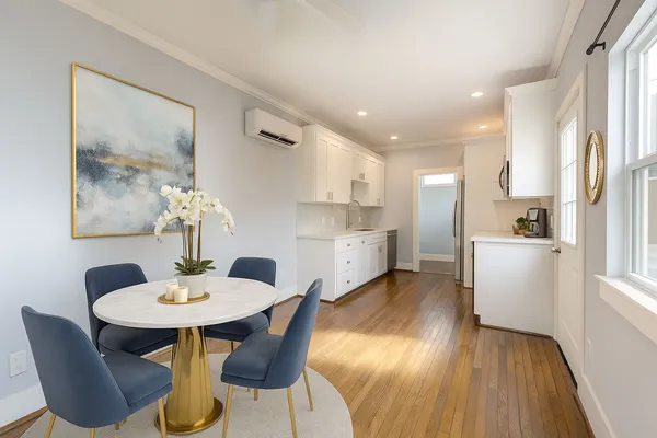 a kitchen with stainless steel appliances kitchen island a table and chairs in it
