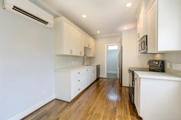 a kitchen with wooden floors and white appliances